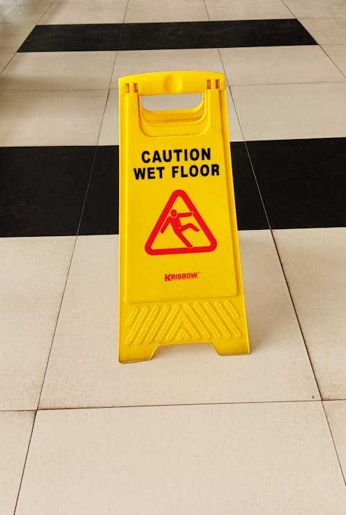 Yellow Caution Wet Floor Sign on Tiled Floor