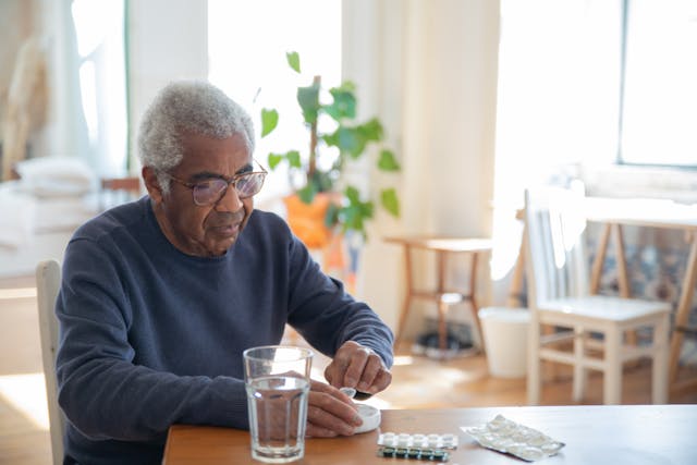 elderly man taking medication pills