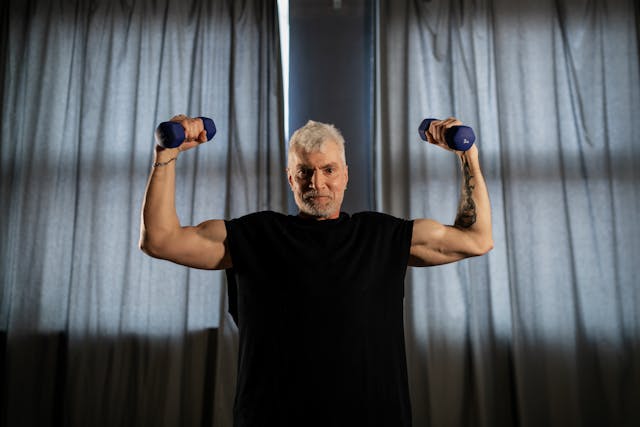 An Elderly Man with muscle Lifting Dumbbells