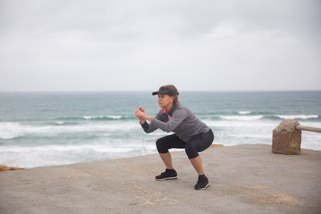 Woman Doing Leg squats Exercise Near the Ocean