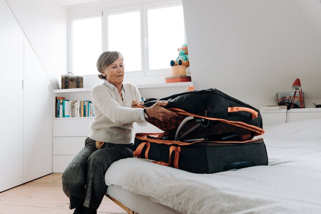 Senior Woman Packing Suitcase for travelling