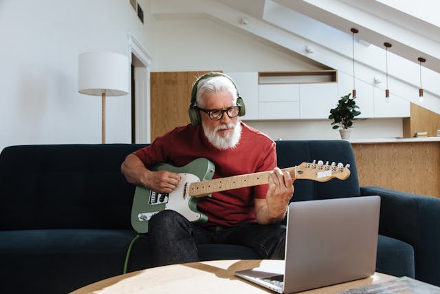 retired man playing music guitar