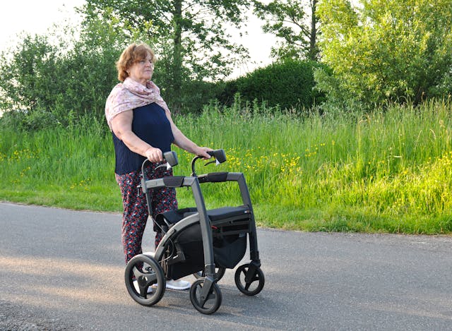 elderly woman walking with a rollator walker