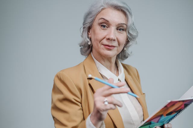 Portrait of Elderly Woman in Brown Blazer Holding a Notebook