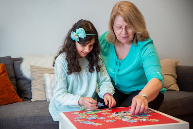 A Woman Putting a Jigsaw Puzzle with Her Granddaughter