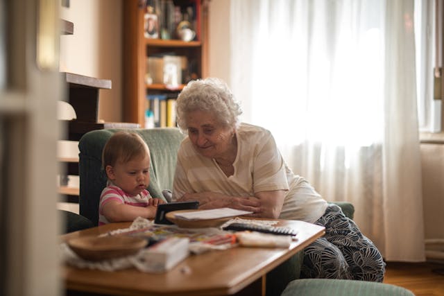 Elderly Woman Sitting on Couch with her grandchild