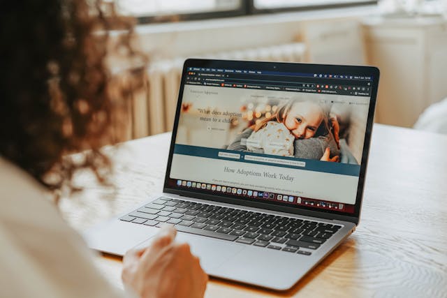 Woman Looking at the Laptop with Adoption Website