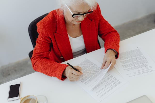 Woman Wearing Black Framed Eyeglasses Signing documents