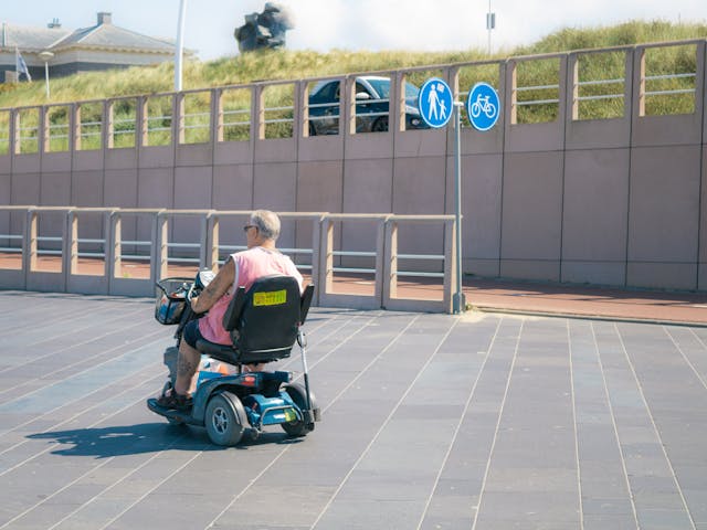 A senior man rides an electric mobility scooter