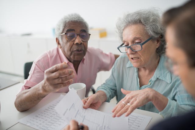 Elderly couple discussing financial document