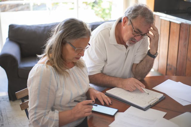 Elderly couple reviewing bills and documents at home