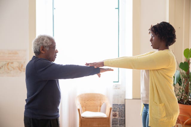 Elderly man and caregiver engaging in exercise